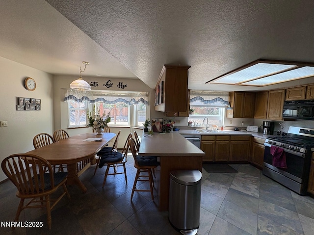 1885 Yale Dr, Carson City, NV 89703 - kitchen featuring appliances with stainless steel finishes, a sink, a peninsula, light countertops, and a kitchen breakfast bar