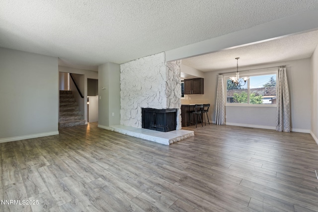 84 Arndell Way, Sparks, NV 89431 - unfurnished living room featuring a textured ceiling, a fireplace, stairway, a chandelier, and wood finished floors