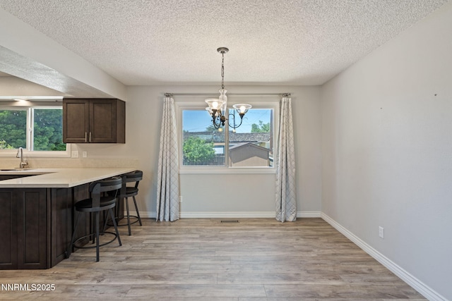 84 Arndell Way, Sparks, NV 89431 - dining area with a textured ceiling, light wood-style floors, a chandelier, and baseboards