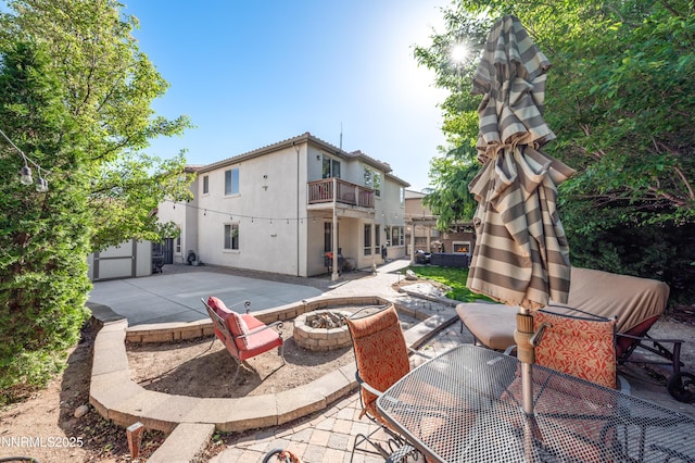471 Shire Ct, Reno, NV 89521 - back of property featuring a balcony, a patio area, an outdoor fire pit, and stucco siding
