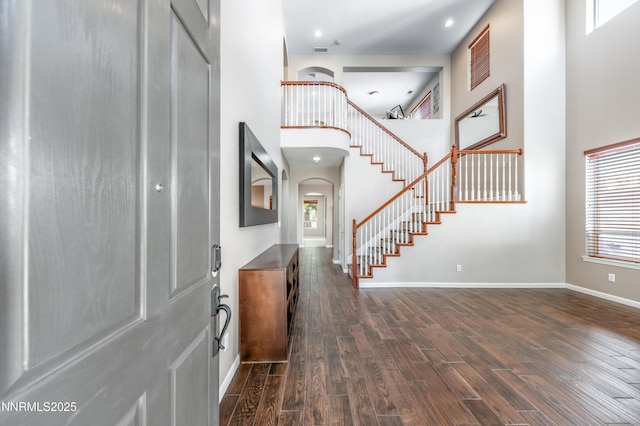471 Shire Ct, Reno, NV 89521 - foyer entrance with stairway, arched walkways, dark wood-type flooring, baseboards, and a towering ceiling