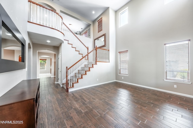 471 Shire Ct, Reno, NV 89521 - foyer featuring a towering ceiling, stairway, arched walkways, dark wood-style floors, and baseboards