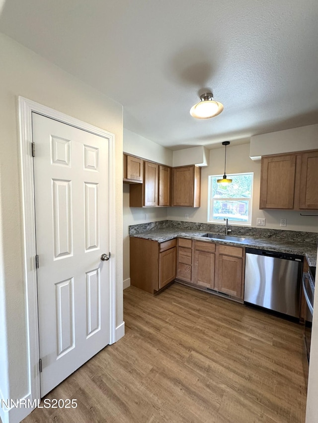 675 E Taylor St, Reno, NV 89502 - kitchen with stainless steel dishwasher, a sink, brown cabinetry, wood finished floors, and decorative light fixtures