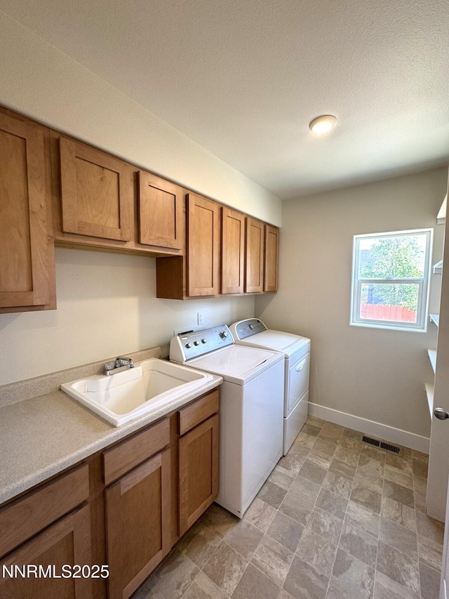 675 E Taylor St, Reno, NV 89502 - washroom with washer and clothes dryer, cabinet space, baseboards, light stone finish floors, and a textured ceiling