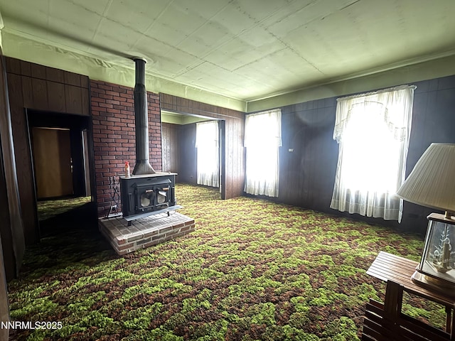 831 N 1st St, Battle Mountain, NV 89820 - unfurnished living room with a wood stove and carpet floors