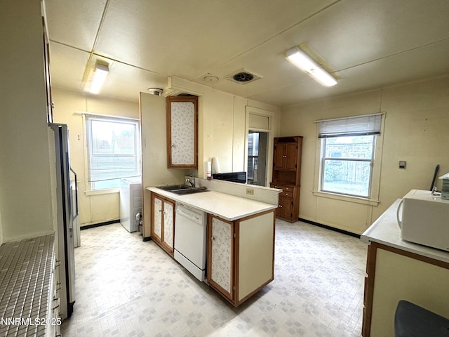 831 N 1st St, Battle Mountain, NV 89820 - kitchen with white appliances, a sink, a peninsula, light floors, and light countertops