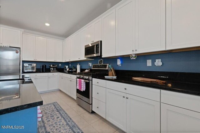 6127 Red Stable Rd, Sparks, NV 89436 - kitchen featuring appliances with stainless steel finishes, white cabinetry, light tile patterned floors, dark countertops, and recessed lighting