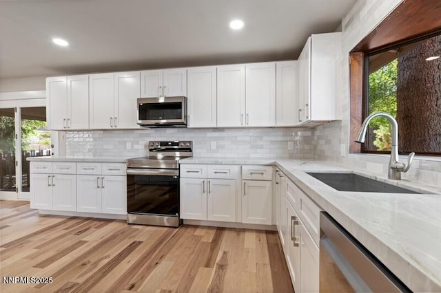 2080 Del Rio Ln, Reno, NV 89509 - kitchen with appliances with stainless steel finishes, a sink, healthy amount of natural light, light wood-type flooring, and recessed lighting