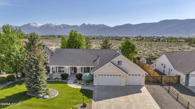 2866 La Cresta Cir, Minden, NV 89423 - view of front facade featuring a garage, a mountain view, driveway, covered porch, and a gate