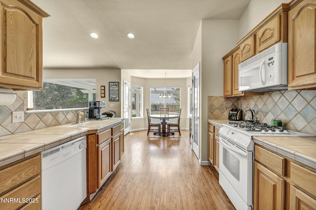 2866 La Cresta Cir, Minden, NV 89423 - kitchen featuring white appliances, a sink, light wood-type flooring, tile counters, and tasteful backsplash