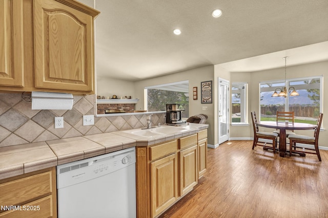 2866 La Cresta Cir, Minden, NV 89423 - kitchen with dishwasher, tasteful backsplash, a chandelier, light wood finished floors, and a sink