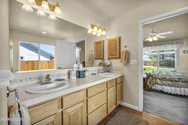 2866 La Cresta Cir, Minden, NV 89423 - ensuite bathroom featuring double vanity, healthy amount of natural light, ceiling fan, and wood finished floors