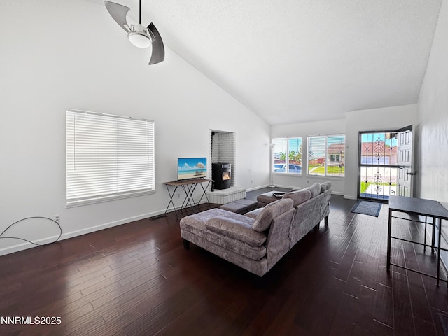 620 W National Ave, Winnemucca, NV 89445 - living area featuring high vaulted ceiling, dark wood-type flooring, a ceiling fan, a brick fireplace, and baseboards