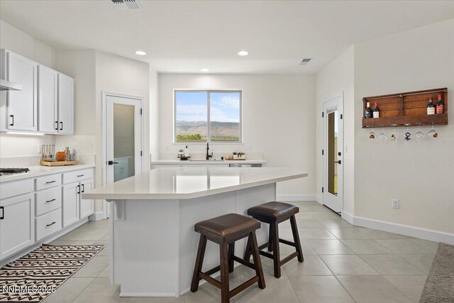11235 Freedom Range Ln, Reno, NV 89521 - kitchen with a breakfast bar, light tile patterned floors, light countertops, white cabinets, and recessed lighting