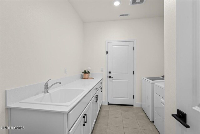 11235 Freedom Range Ln, Reno, NV 89521 - laundry area featuring washing machine and clothes dryer, cabinet space, and light tile patterned floors