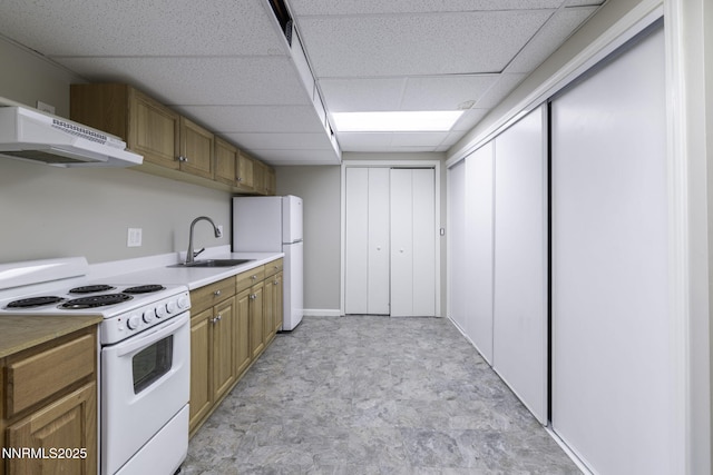 16360 Jefte Ct, Reno, NV 89511 - kitchen with white appliances, under cabinet range hood, a paneled ceiling, light countertops, and brown cabinets