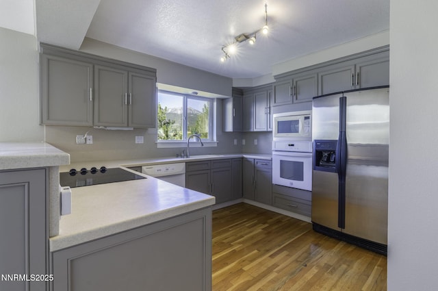 16360 Jefte Ct, Reno, NV 89511 - kitchen with white appliances, gray cabinetry, light wood-style flooring, and light countertops