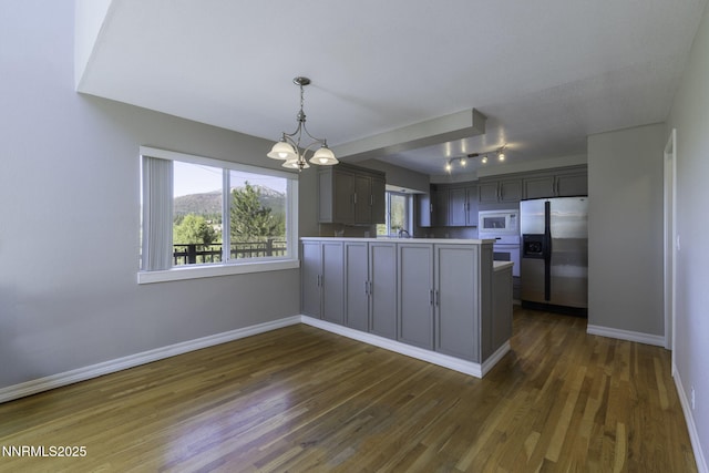 16360 Jefte Ct, Reno, NV 89511 - kitchen featuring white appliances, a chandelier, dark wood finished floors, a peninsula, and light countertops