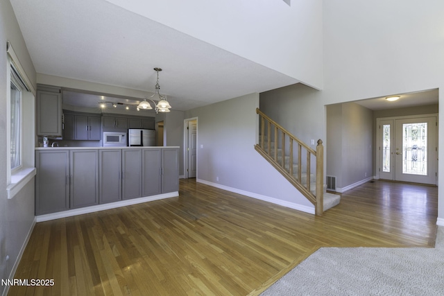 16360 Jefte Ct, Reno, NV 89511 - kitchen featuring freestanding refrigerator, white microwave, gray cabinets, wood finished floors, and open floor plan