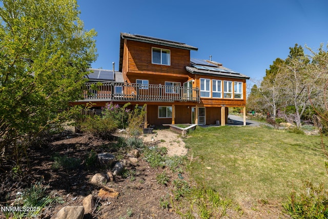 16360 Jefte Ct, Reno, NV 89511 - back of house featuring roof mounted solar panels, a yard, a wooden deck, and a sunroom