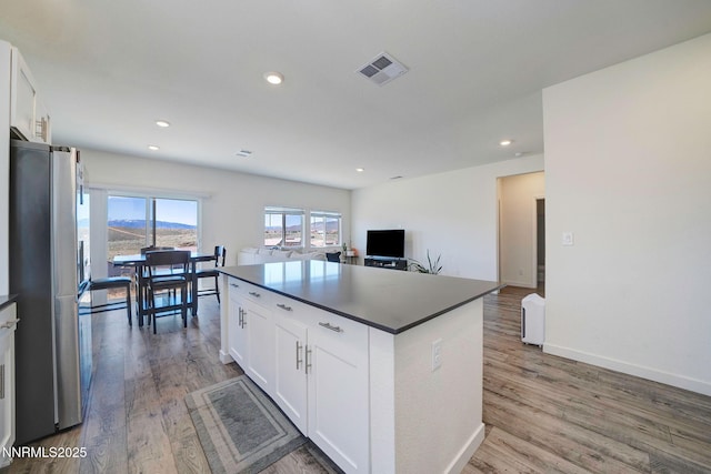 2040 Painted Sky Way, Sun Valley, NV 89433 - kitchen featuring freestanding refrigerator, dark countertops, white cabinetry, light wood-style flooring, and a kitchen island