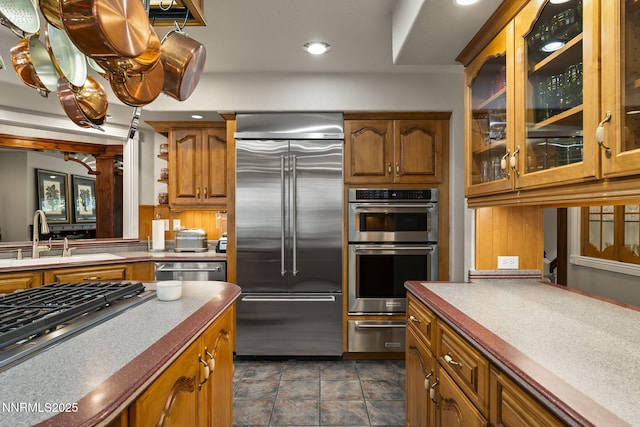 30 Francovich Ct, Reno, NV 89519 - kitchen featuring appliances with stainless steel finishes, a warming drawer, a sink, brown cabinetry, and glass insert cabinets