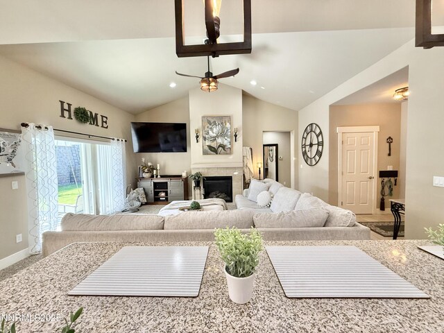 3221 Hackamore Way, Winnemucca, NV 89445 - living area featuring ceiling fan, a tiled fireplace, vaulted ceiling, recessed lighting, and baseboards