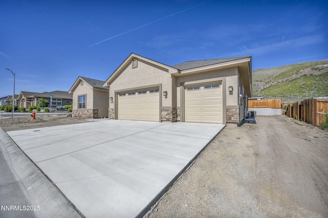 3952 Siena Dr, Carson City, NV 89703 - view of front of home featuring stone siding, a garage, stucco siding, and concrete driveway