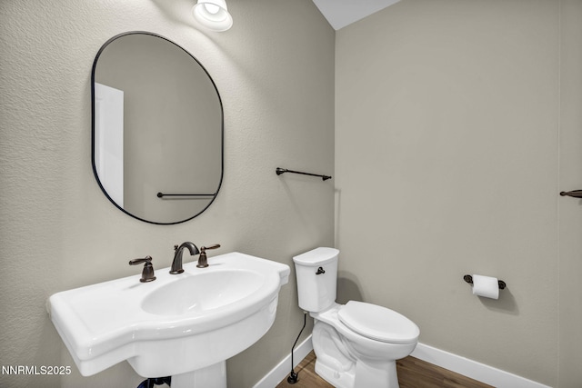 3952 Siena Dr, Carson City, NV 89703 - half bath featuring wood finished floors, toilet, baseboards, and a sink