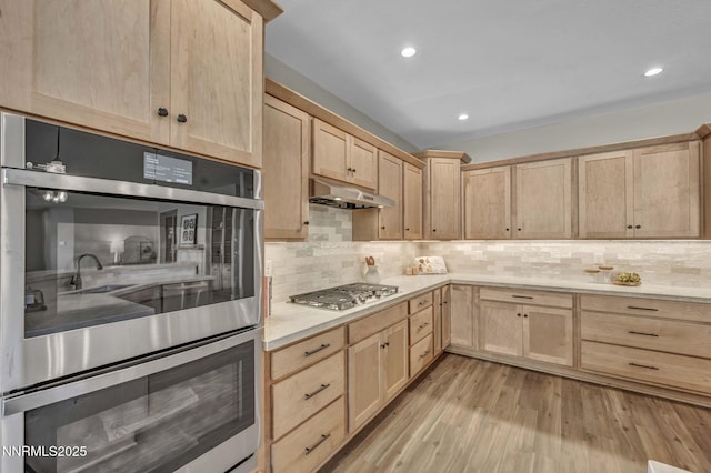 3952 Siena Dr, Carson City, NV 89703 - kitchen with light brown cabinetry, appliances with stainless steel finishes, under cabinet range hood, light countertops, and recessed lighting