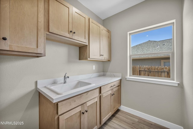 3952 Siena Dr, Carson City, NV 89703 - kitchen featuring light brown cabinetry, a sink, baseboards, light wood-style flooring, and light countertops