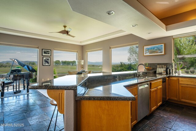 2473 Genoa Aspen Dr, Genoa, NV 89411 - kitchen featuring stone tile flooring, stainless steel dishwasher, a sink, a tray ceiling, and recessed lighting