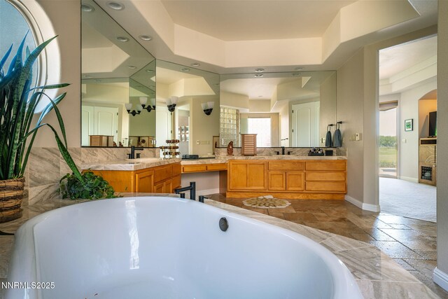 2473 Genoa Aspen Dr, Genoa, NV 89411 - full bathroom featuring stone tile flooring, a tub, baseboards, vanity, and recessed lighting