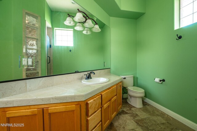 2473 Genoa Aspen Dr, Genoa, NV 89411 - bathroom featuring vanity, toilet, a stall shower, baseboards, and stone finish floors