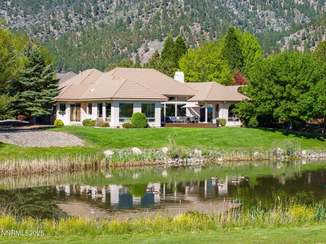 2473 Genoa Aspen Dr, Genoa, NV 89411 - rear view of property featuring a tiled roof, a water and mountain view, a chimney, stucco siding, and a yard