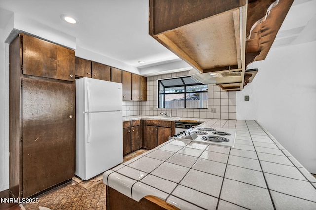 1129 Sonoma St, Carson City, NV 89701 - kitchen with white appliances, tile counters, tasteful backsplash, a sink, and a peninsula
