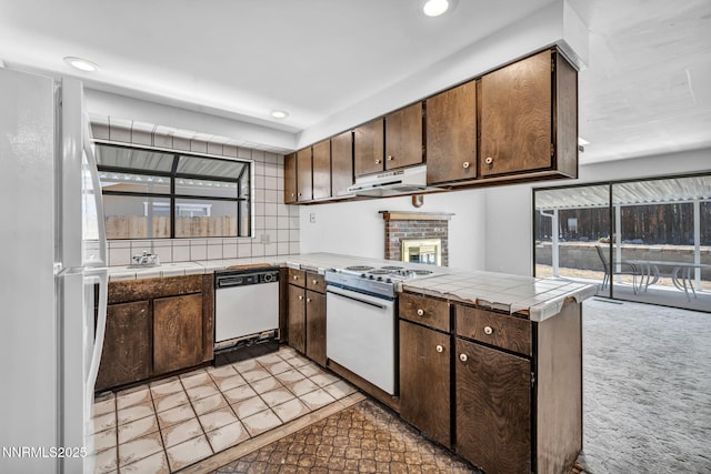 1129 Sonoma St, Carson City, NV 89701 - kitchen with white appliances, under cabinet range hood, tile counters, a peninsula, and recessed lighting
