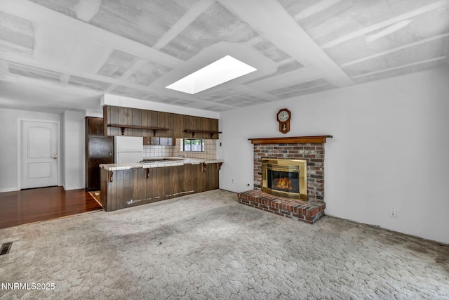 1129 Sonoma St, Carson City, NV 89701 - unfurnished living room featuring a skylight, carpet flooring, and a brick fireplace