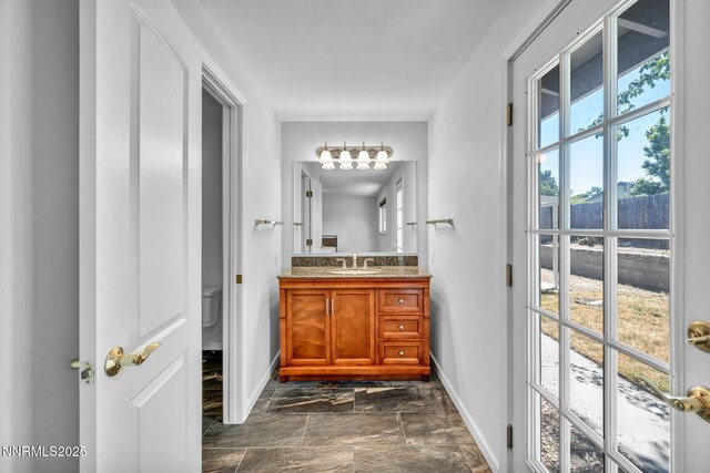 1129 Sonoma St, Carson City, NV 89701 - bathroom featuring baseboards, vanity, stone finish floors, and toilet