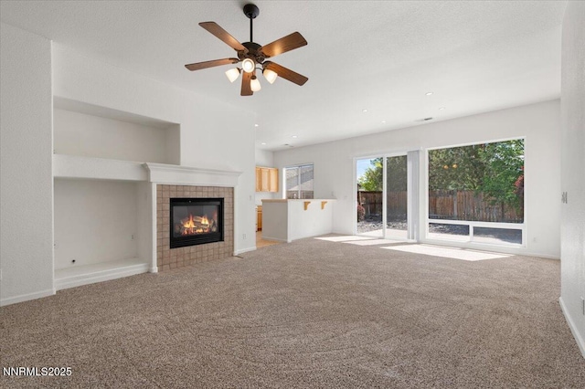 10548 Bliss Ct, Reno, NV 89521 - unfurnished living room with carpet flooring, a tile fireplace, a ceiling fan, and baseboards