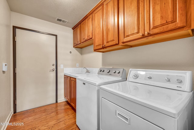 9900 Wilbur May Pkwy Apt 2801, Reno, NV 89521 - laundry area with light wood-style flooring, independent washer and dryer, cabinet space, baseboards, and a textured ceiling
