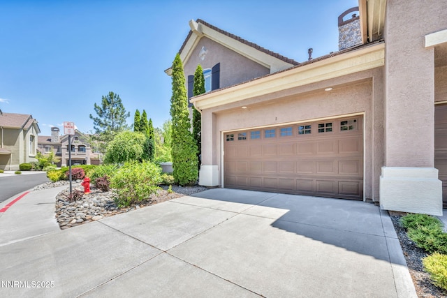 9900 Wilbur May Pkwy Apt 2801, Reno, NV 89521 - view of side of home with driveway, stucco siding, and an attached garage