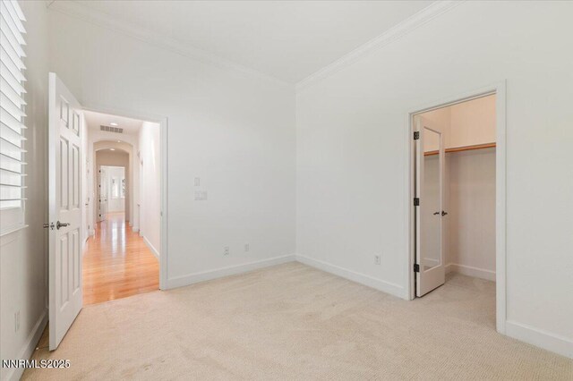 2728 Spirit Rock Trl, Reno, NV 89511 - unfurnished bedroom with ornamental molding, light colored carpet, arched walkways, baseboards, and a walk in closet