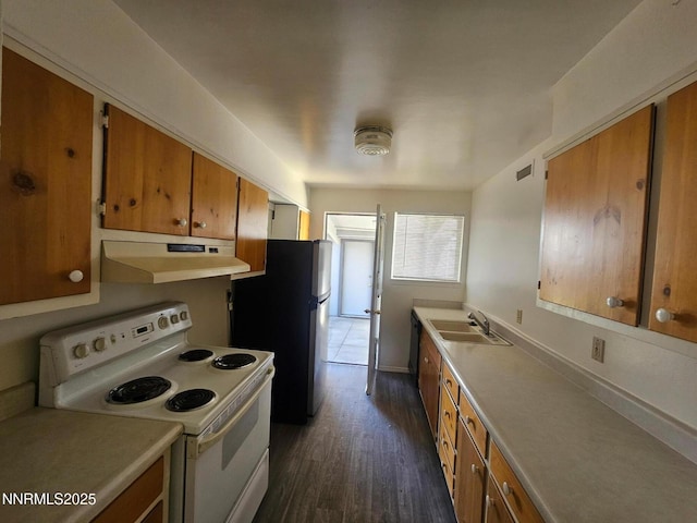 11303 Green Mountain St, Reno, NV 89506 - kitchen with white electric stove, under cabinet range hood, a sink, brown cabinetry, and dark wood-style floors