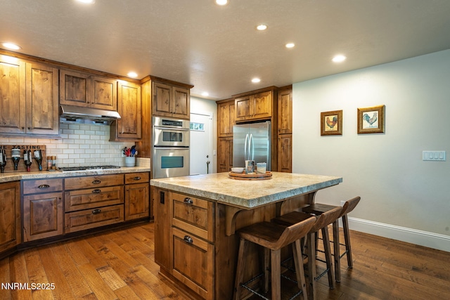 625 Freel Dr, Zephyr Cove, NV 89448 - kitchen featuring stainless steel appliances, under cabinet range hood, dark wood-style floors, recessed lighting, and decorative backsplash
