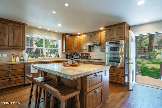 625 Freel Dr, Zephyr Cove, NV 89448 - kitchen featuring appliances with stainless steel finishes, a kitchen island, recessed lighting, dark wood-style flooring, and tasteful backsplash