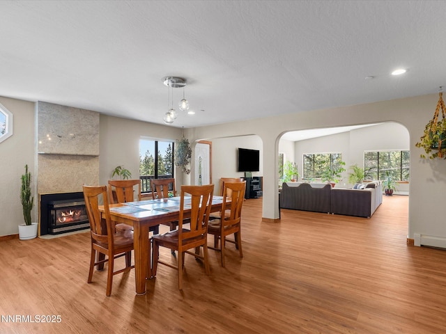 315 Paiute Dr, Zephyr Cove, NV 89448 - dining room with arched walkways, healthy amount of natural light, wood finished floors, a fireplace, and recessed lighting