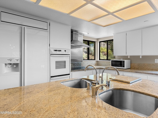 315 Paiute Dr, Zephyr Cove, NV 89448 - kitchen with white appliances, wall chimney exhaust hood, white cabinets, and light stone counters