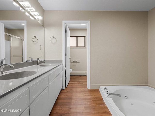 315 Paiute Dr, Zephyr Cove, NV 89448 - full bath featuring double vanity, a baseboard heating unit, wood finished floors, a tub with jets, and a shower stall
