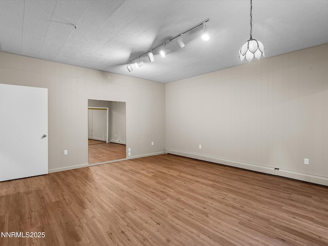 315 Paiute Dr, Zephyr Cove, NV 89448 - empty room with light wood finished floors, track lighting, and a baseboard heating unit